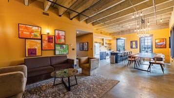 A spacious living area with a sofa, coffee table, and artwork on the walls.