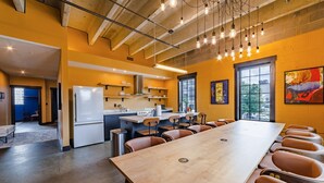 A modern kitchen with a long dining table and chairs, a refrigerator, and a window with a view. - Sleep38 27Beds 10BR Super Stays A12 Up E Crown DD (Louisville)