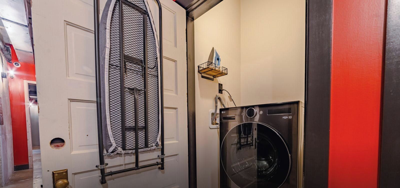 A laundry area with a washing machine and a drying rack.