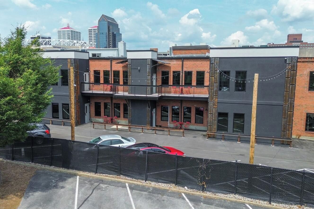 A multi-story building with a parking lot in front.