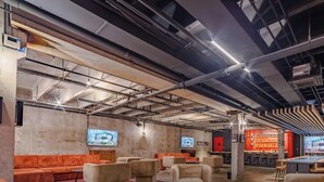 Moderne interiør med blotlagte lofter, siddepladser og en bar.