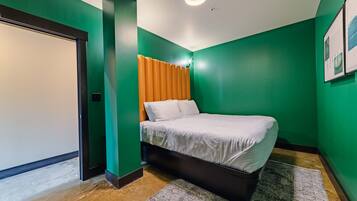 Une chambre à coucher avec un lit, une porte et un mur vert.