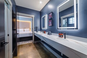 A modern bathroom with a long white countertop, a large mirror, and a bed visible through an open door. - Sleep24 12Beds 8BR Super Stays A12 Low W Stakes Ex (Louisville)
