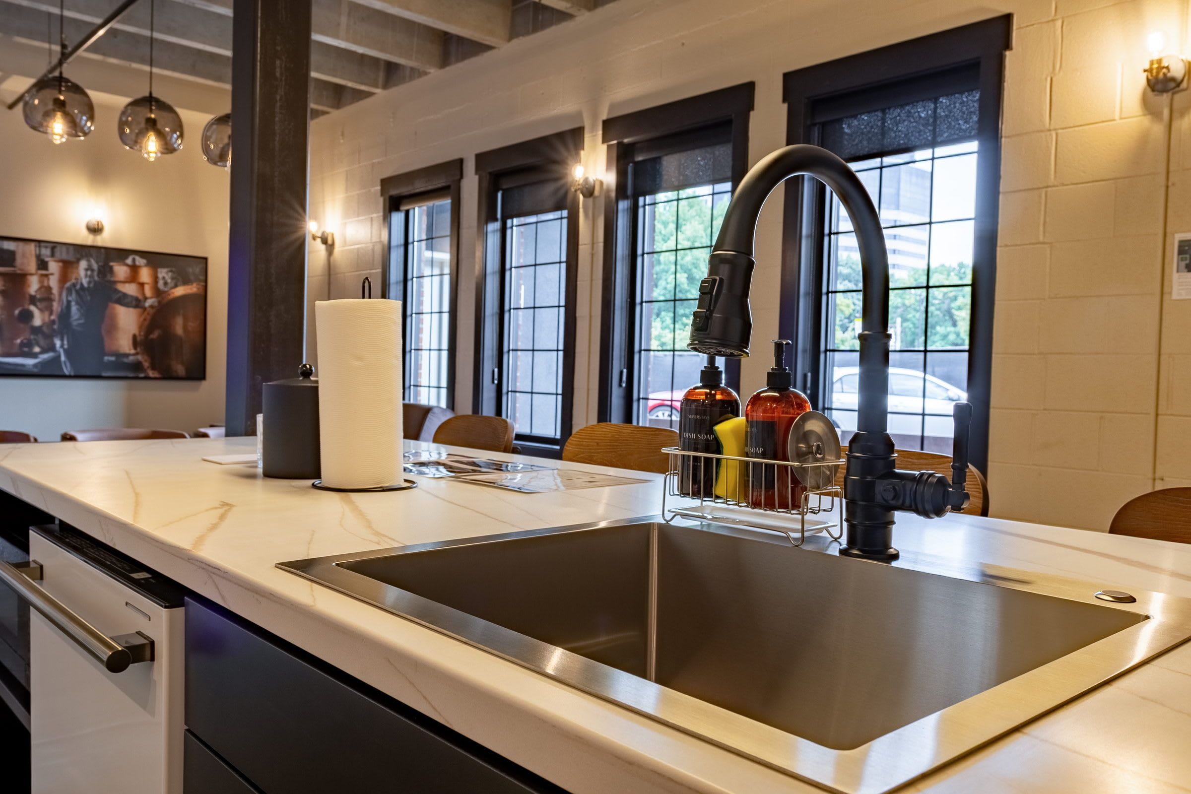 A modern kitchen with a stainless steel sink, a faucet, and a dish soap dispenser.