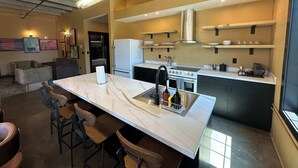 Een moderne keuken met een marmeren aanrechtblad, een ingebouwde oven en een roestvrijstalen afzuigkap.