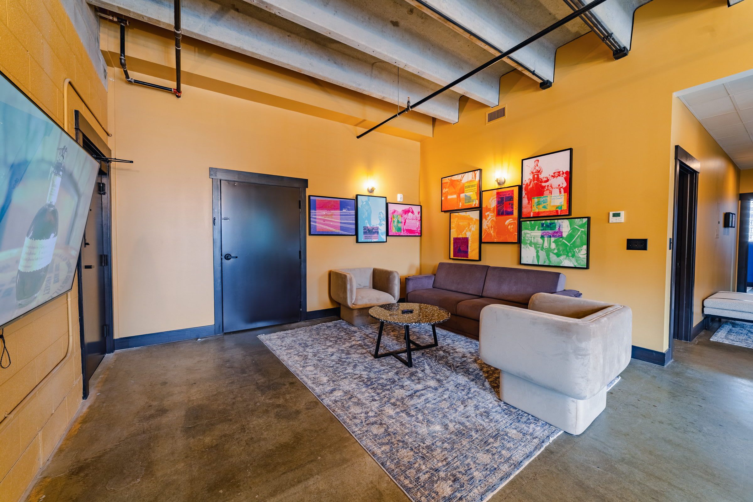 A modern interior with a sofa, armchairs, a coffee table, and artwork on the walls.