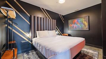 A modern bedroom with a bed, a nightstand, a lamp, and a wall art piece.