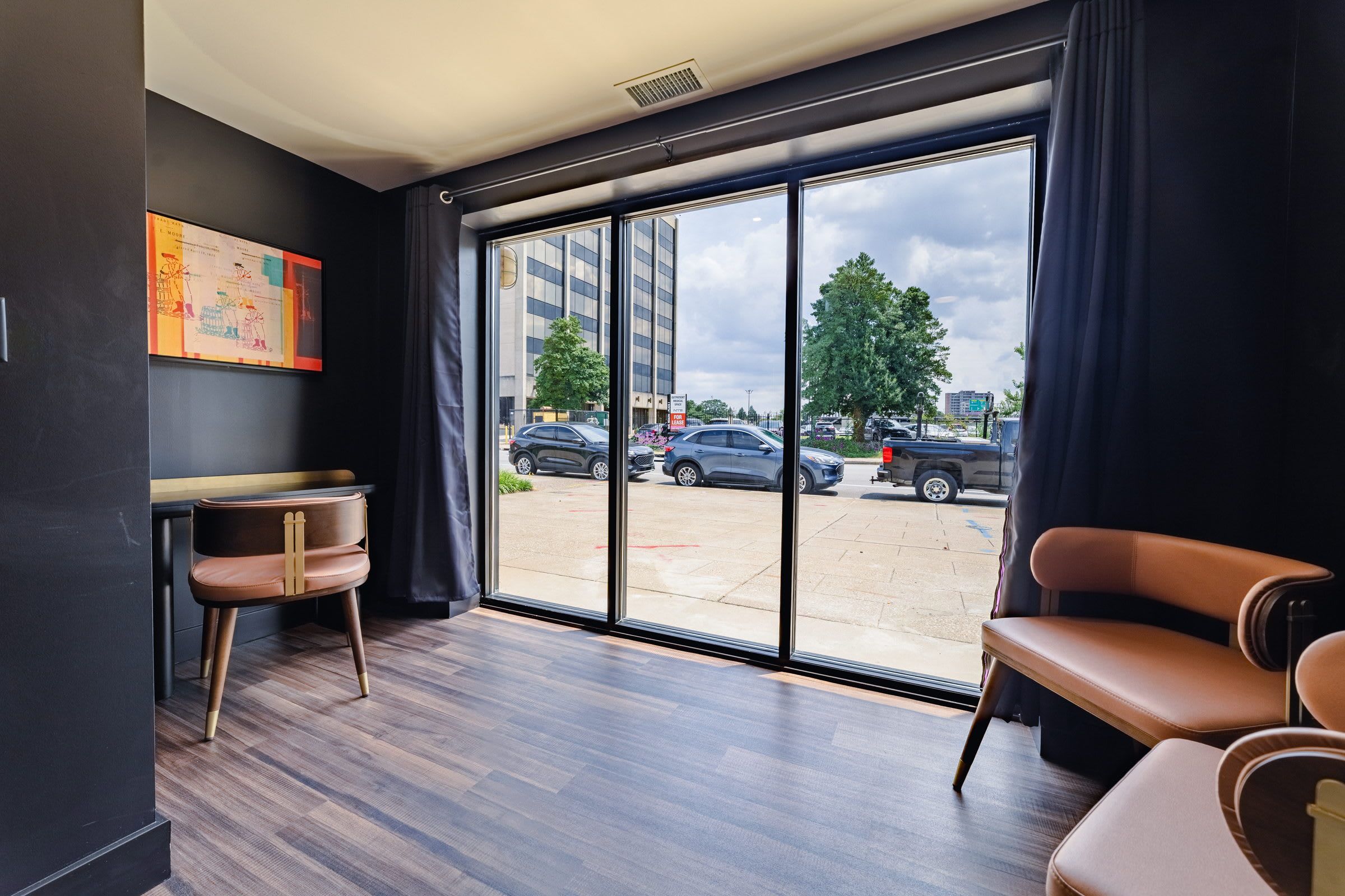 Une chambre moderne dotée d’une grande fenêtre, d’un bureau et de deux chaises.