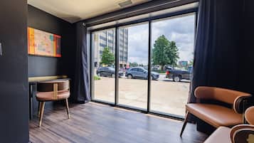 Une chambre moderne dotée d’une grande fenêtre, d’un bureau et de deux chaises.