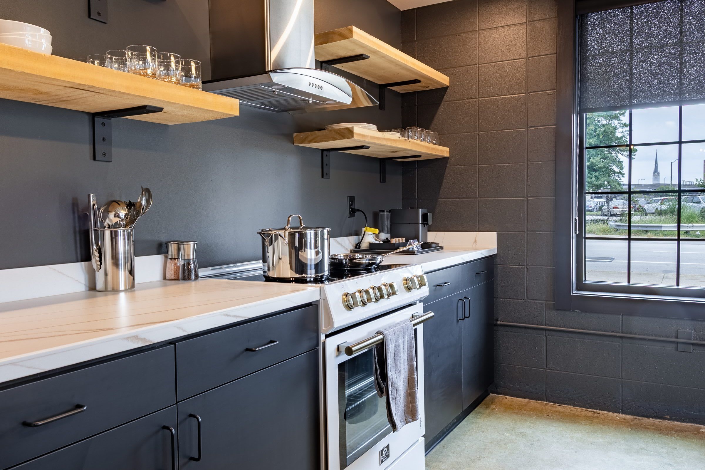 A modern kitchen with a stove, oven, and various kitchen utensils.