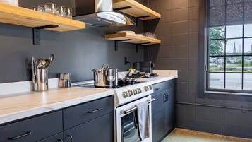 A modern kitchen with a stove, oven, and various kitchen utensils.