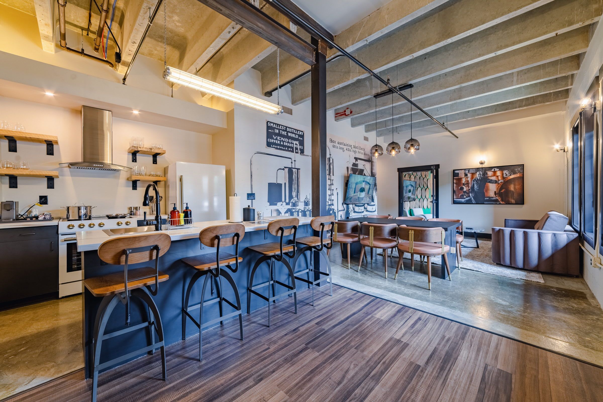 Une cuisine moderne avec un coin bar, des tabourets de bar en bois et un grand îlot central.