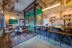 Eine moderne Bar mit Hockern, einer Theke und einer Wand mit runden Verzierungen.