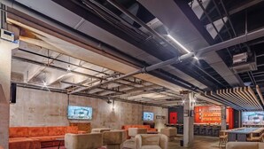 Een modern interieur met open plafonds, zithoeken en een bar.
