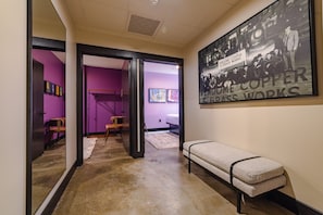 A hallway with a bench, a framed historical photograph, and a door leading to another room. - Sleep48 24Beds 16BR Super Stays A12 Pad Superfecta (Louisville)