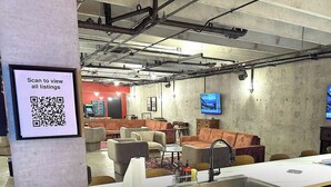 Et moderne loungeområde med sofaer, et sofabord og et langt bord med vask.