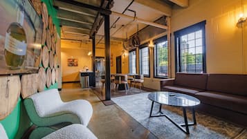 Un intérieur moderne comprenant un coin salon, une cuisine et de grandes fenêtres.