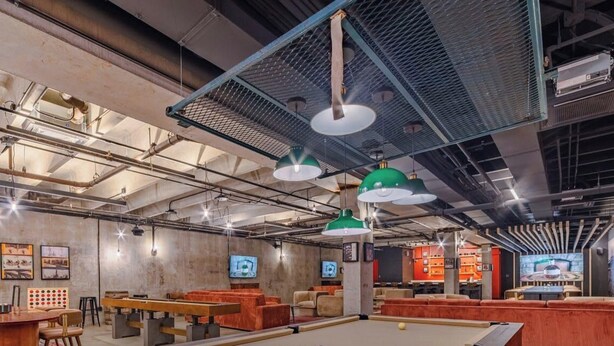 Un espace de détente moderne, doté de sièges, de tables et d’une table de billard.