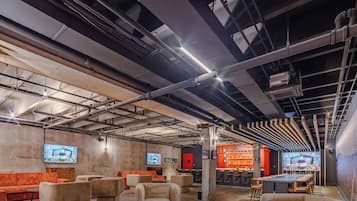 A modern interior with exposed ceilings, seating areas, and a bar.
