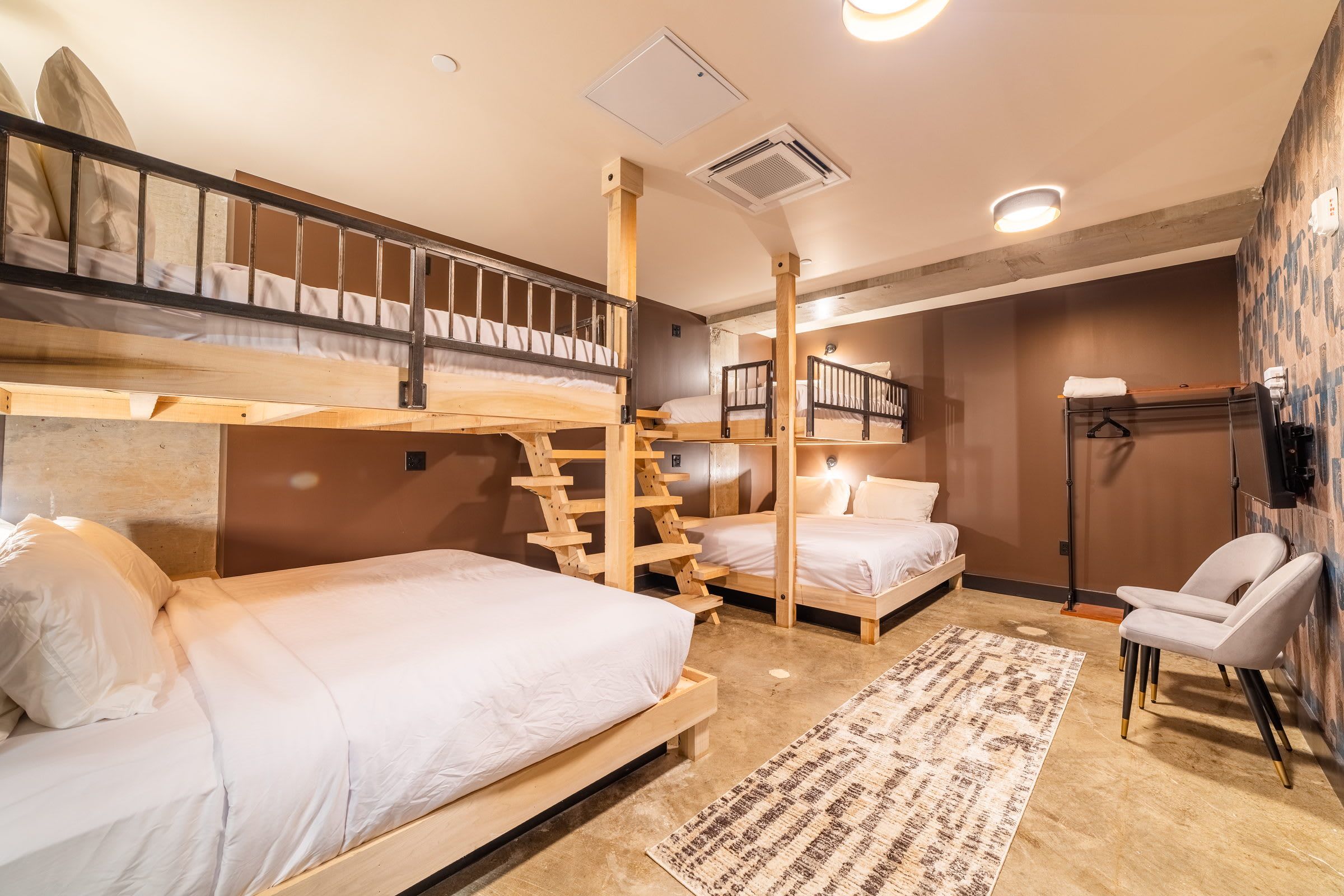 A compact room with bunk beds, a small desk, and a chair.
