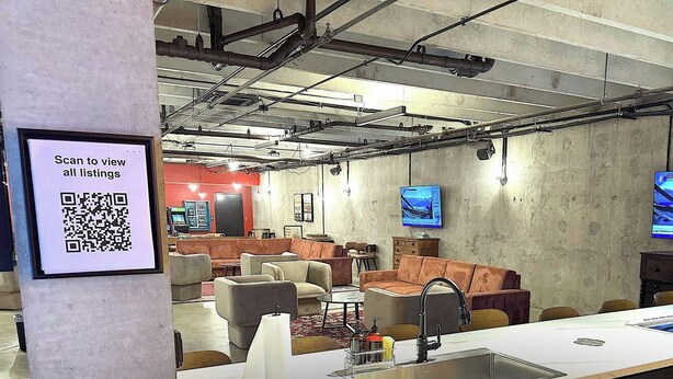 Un espace détente moderne avec des canapés, une table basse et une longue table équipée d’un évier.