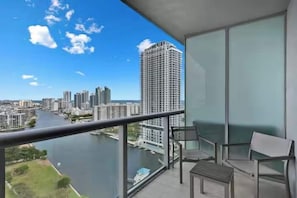 A balcony with a view of a river and cityscape, including high-rise buildings. - High-Floor Studio Intracoastal View (Hallandale Beach)