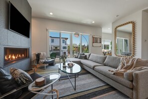 Ein Wohnzimmer mit Kamin, einer Couch, einem Couchtisch und einem großen Spiegel.