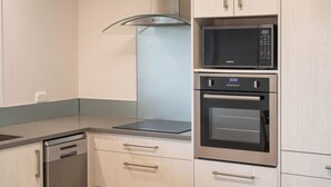A modern kitchen with a dishwasher, microwave, and oven.