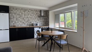 A modern kitchen with a dining area, a washing machine, and a large window. - La Mimosa Apartment 2607 (San Miguel de Meruelo)