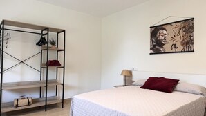 A bedroom with a bed, a shelf unit, and a wall-mounted artwork. - La Mimosa Apartment 2607 (San Miguel de Meruelo)