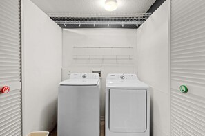 A laundry room with two white washers and dryers, a ceiling vent, and a wall-mounted drying rack. - Family Getaway with Pool and Game Room (Davenport)