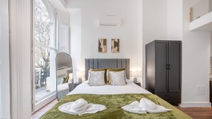 Ein Hotelzimmer mit einem großen Bett, einem Kleiderschrank und Blick ins Freie.
