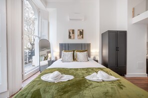 Ein Hotelzimmer mit einem großen Bett, einem Kleiderschrank und Blick ins Freie.