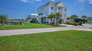 A two-story house with a front porch, a covered driveway, and a small boat dock. - Canalfront dock with hot tub and views (North Topsail Beach)