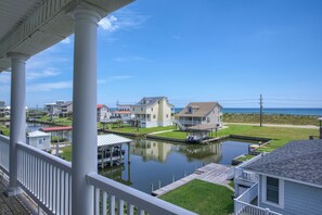 A waterfront property with a dock, a small boat, and a clear view of the ocean. - Canalfront dock with hot tub and views (North Topsail Beach)