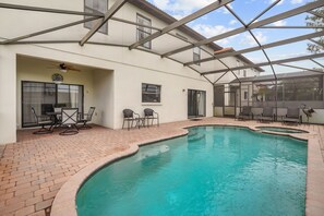 A swimming pool with a patio area, chairs, and a ceiling fan. - Cozy 5BD 3,5BA Clermont Villa/Heated Pool/Parks (Clermont)