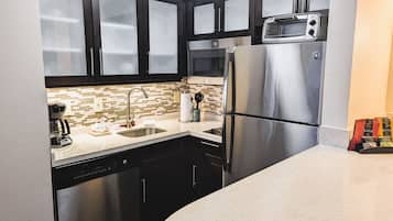 A modern kitchen with stainless steel appliances, a dishwasher, and a microwave.