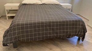Ein Schlafzimmer mit einem Bett, zwei Nachttischen und einem Fenster.