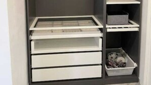 A walk-in closet with multiple shelves, drawers, and hanging space.