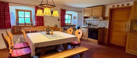 A cozy kitchen with wooden furniture, a dining table, and a bench.