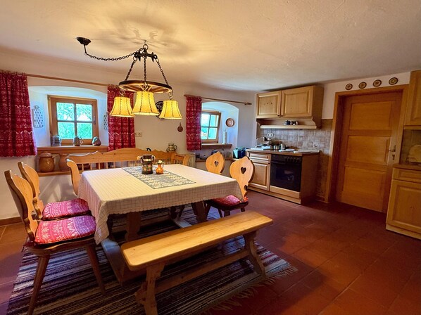 A cozy kitchen with wooden furniture, a dining table, and a bench.