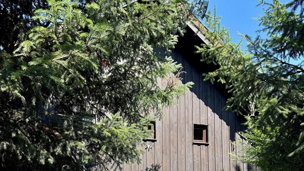 A two-story building with a wooden exterior and a white lower section. - Joslheisl Breitenberg (Breitenberg)