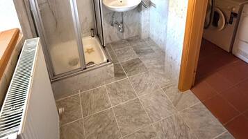 A bathroom with a shower, sink, and a mirror.