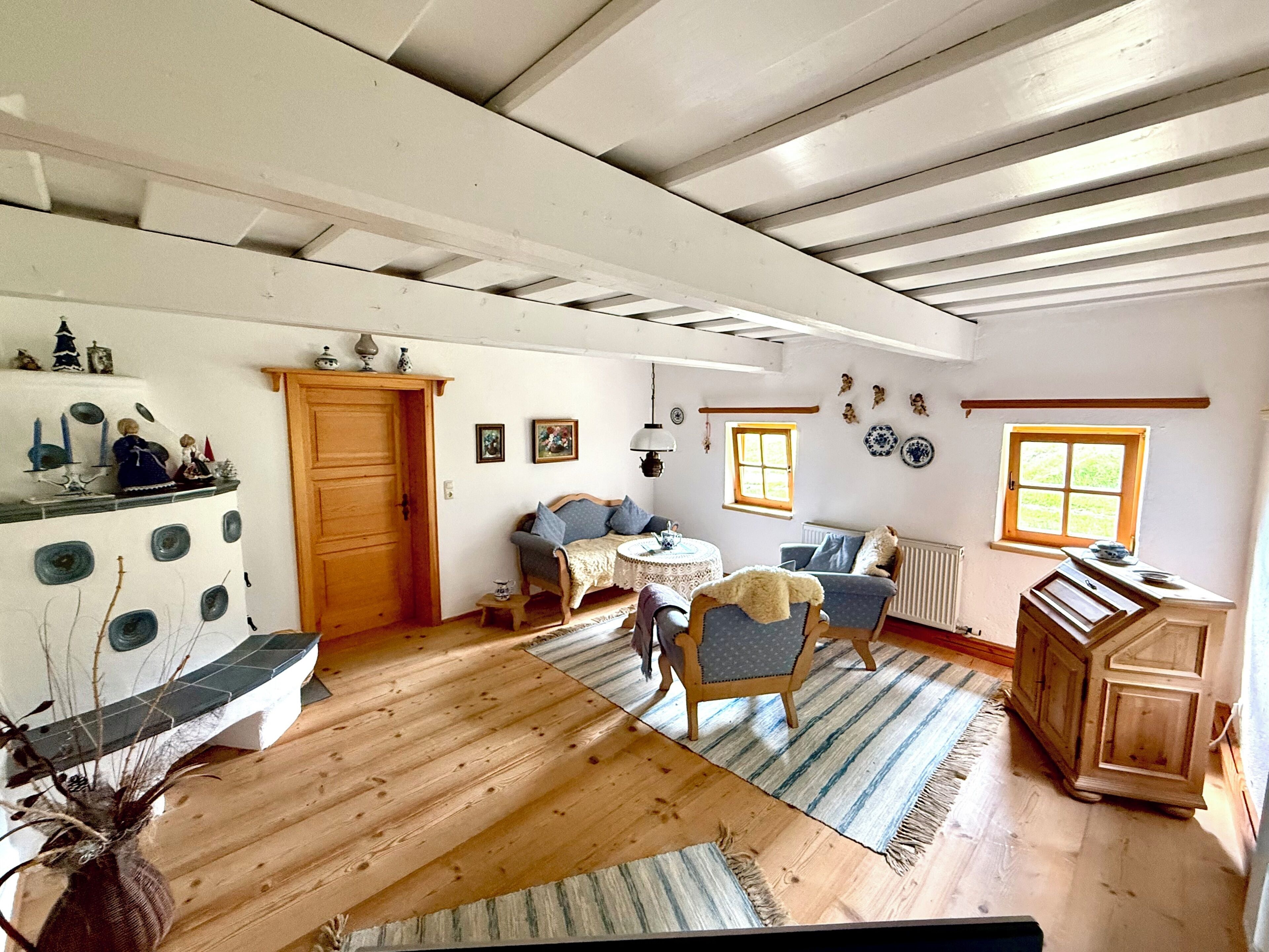 Una habitación con pisos de madera, un sofá, una mesa y un armario.