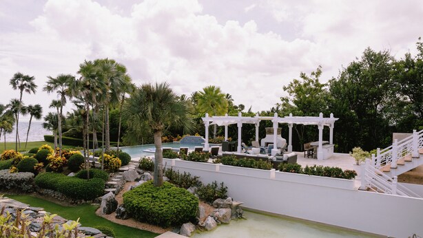 A pool area with a white pergola, palm trees, and a stone pathway. - Luxury9BR Villa39 Juanillo Private Beach (Punta Cana)