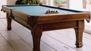 A pool table in a room with a large window, a flat-screen TV on the wall, and a potted plant. - Luxury9BR Villa39 Juanillo Private Beach (Punta Cana)