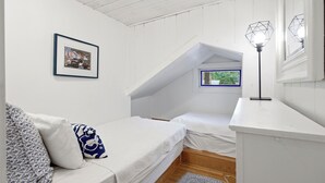 A bedroom with a loft bed, a framed picture on the wall, and a window with a view of greenery. - Highland Lake Cottage/Waterfront/Dock/Kayaks (Windham)