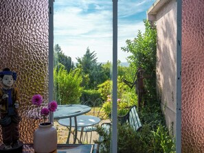 A garden patio with a statue, a table, and chairs. - Maison Rose by Interhome (Deauville-Trouville)