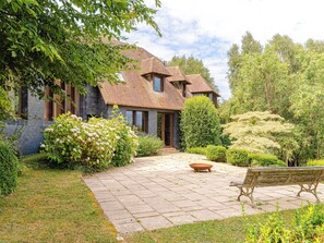 A house with a stone pathway leading to the entrance, surrounded by lush greenery and a bench. - Le Chant d'Azif by Interhome (Deauville-Trouville)