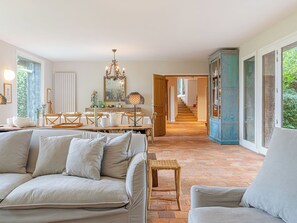 A spacious living area with a sofa, dining table, and a staircase leading to another level. - Le Chant d'Azif by Interhome (Deauville-Trouville)